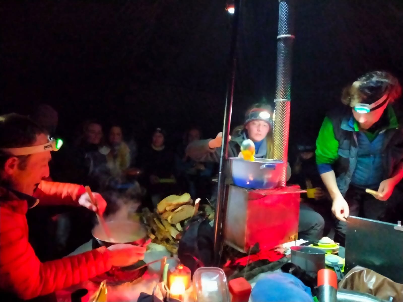 Préparation du dîner autour du poêle à bois, à la lampe frontale